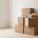 Stacked boxes in a bright, empty room as a calm image of a cluttered home after clearance